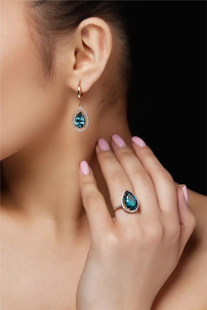 model shows earrings ring with beautiful blue precious stones